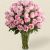 florero de cristal con rosas color rosado y follajes verdes 